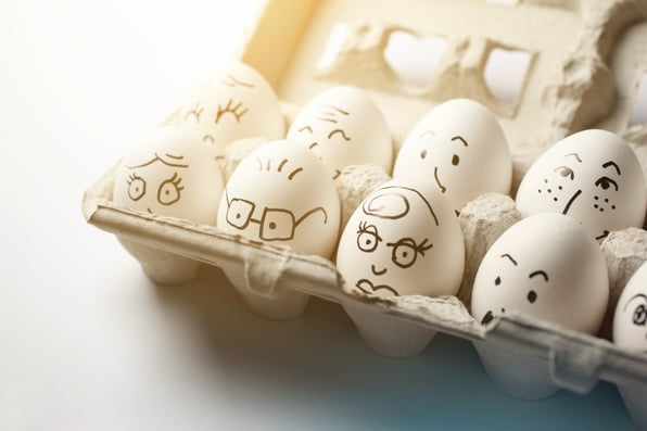 eggs with faces in a carton
